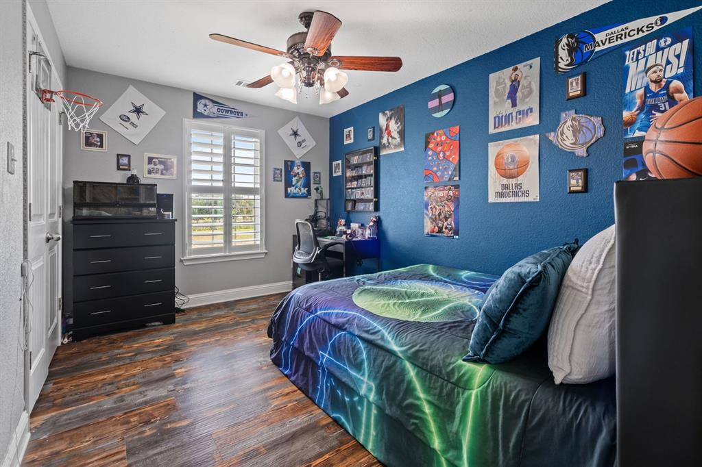 175 Porter Road Bartonville, TX 76226 - Photo 27 of 40 Spacious secondary bedroom featuring warm farmhouse-inspired luxury vinyl floors, great natural light from a window with scenic views, a walk-in closet, and a ceiling fan.