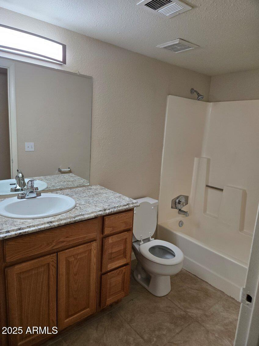 6008 West Acoma Drive Glendale, AZ 85306 - Photo 9 of 14 a bathroom with a granite countertop toilet a sink and a mirror