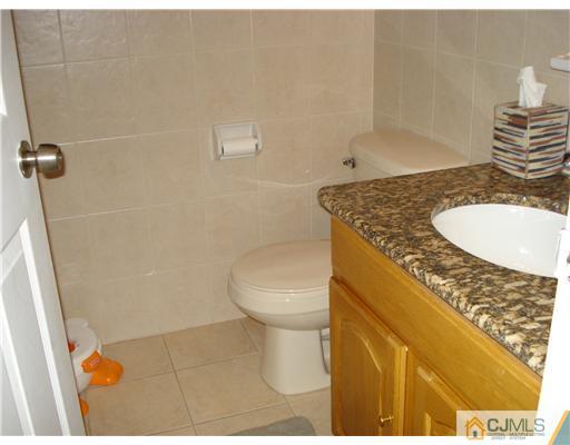 9 Lafayette Street Carteret, NJ 07008 - Photo 12 of 18 a bathroom with a granite countertop sink and a toilet