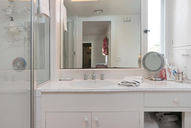 a bathroom with a granite countertop sink and a mirror