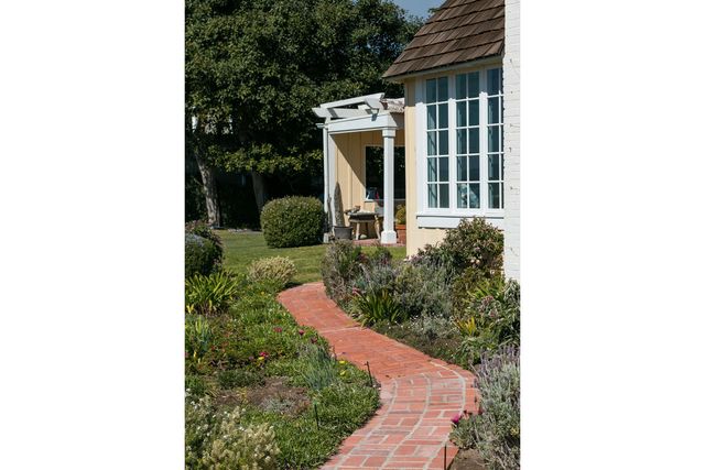 a view of a house with a yard and pathway