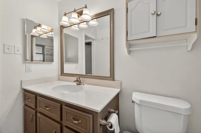 a bathroom with a sink a toilet and a mirror