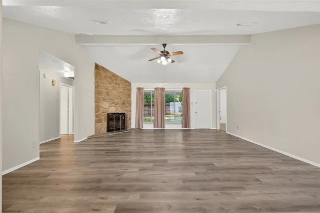 a view of an empty room with a fireplace and a window