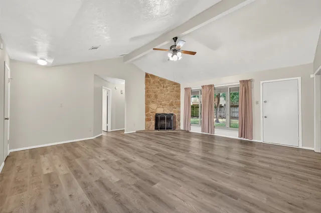 a view of an empty room with a fireplace and a window