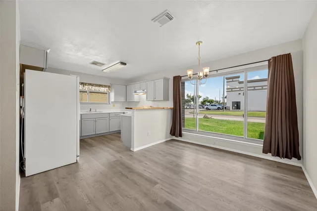 a open kitchen with refrigerator a oven and a large window
