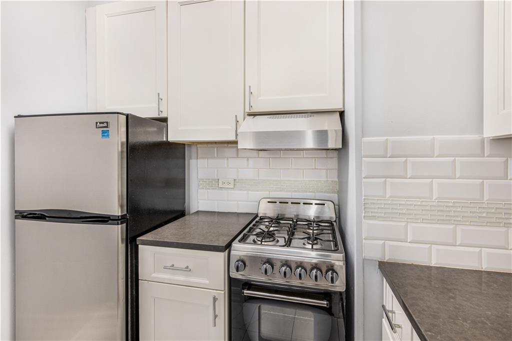 7259 Shore Road, Unit 3A Brooklyn, NY 11209 - Photo 3 of 11 a kitchen with a stove and a refrigerator