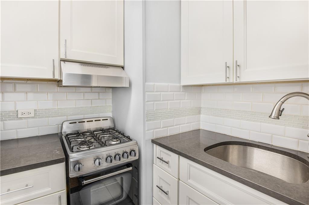 7259 Shore Road, Unit 3A Brooklyn, NY 11209 - Photo 4 of 11 a kitchen with granite countertop a sink a stove and cabinets