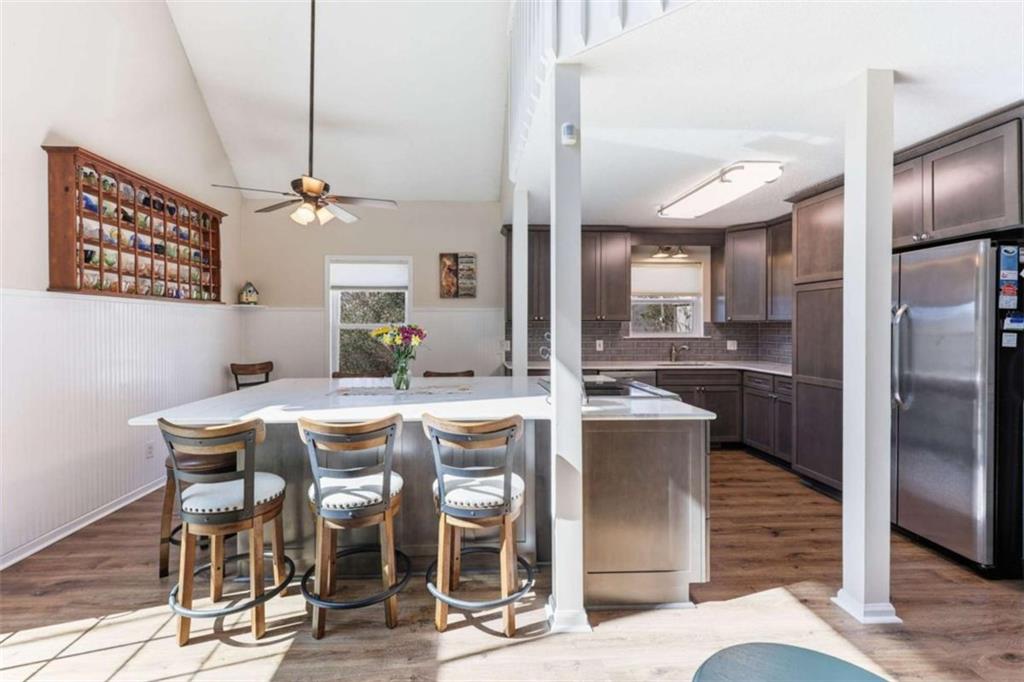 4033 Mt Vernon Road Gainesville, GA 30506 - Photo 13 of 47 a kitchen with stainless steel appliances kitchen island granite countertop a refrigerator a stove a microwave oven a dining table and chairs with wooden floor