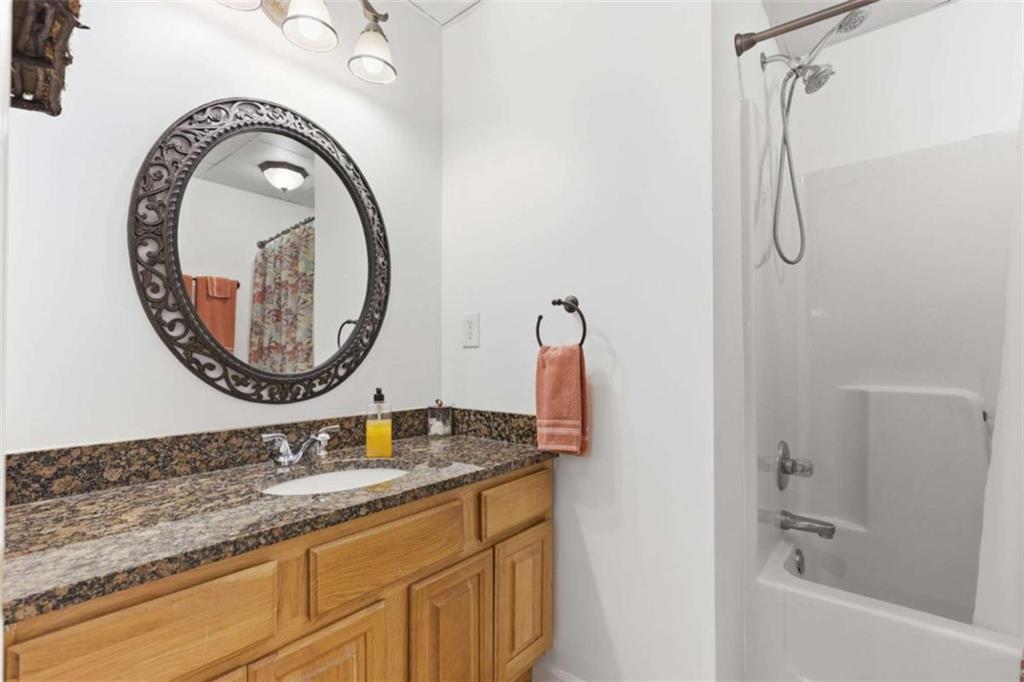 4033 Mt Vernon Road Gainesville, GA 30506 - Photo 35 of 47 a bathroom with a granite countertop sink a mirror and a shower