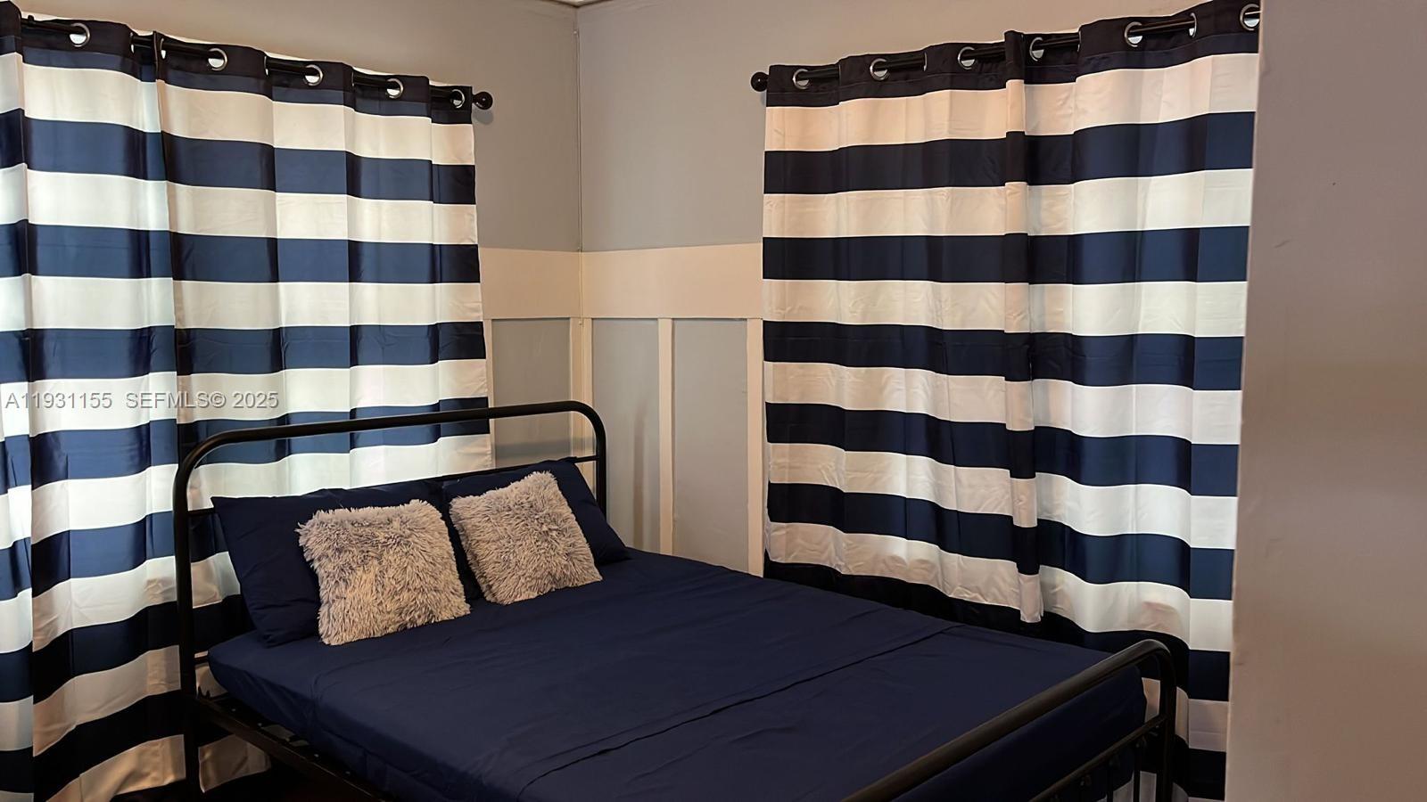 1535 Southwest 2nd Street Miami, FL 33135 - Photo 22 of 38 a bedroom with a bed and a shower curtain