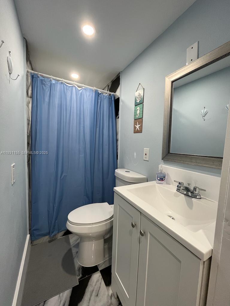 1535 Southwest 2nd Street Miami, FL 33135 - Photo 27 of 38 a bathroom with a sink a toilet a mirror and vanity