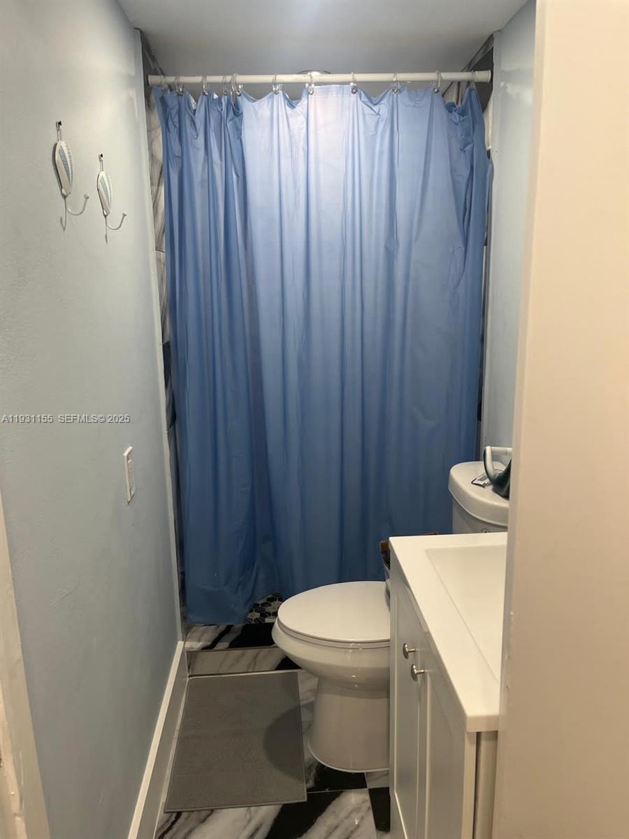1535 Southwest 2nd Street Miami, FL 33135 - Photo 28 of 38 a white toilet sitting next to a shower curtain