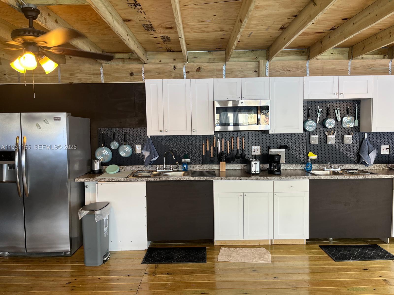 1535 Southwest 2nd Street Miami, FL 33135 - Photo 7 of 38 a kitchen with kitchen island granite countertop a sink cabinets and stainless steel appliances