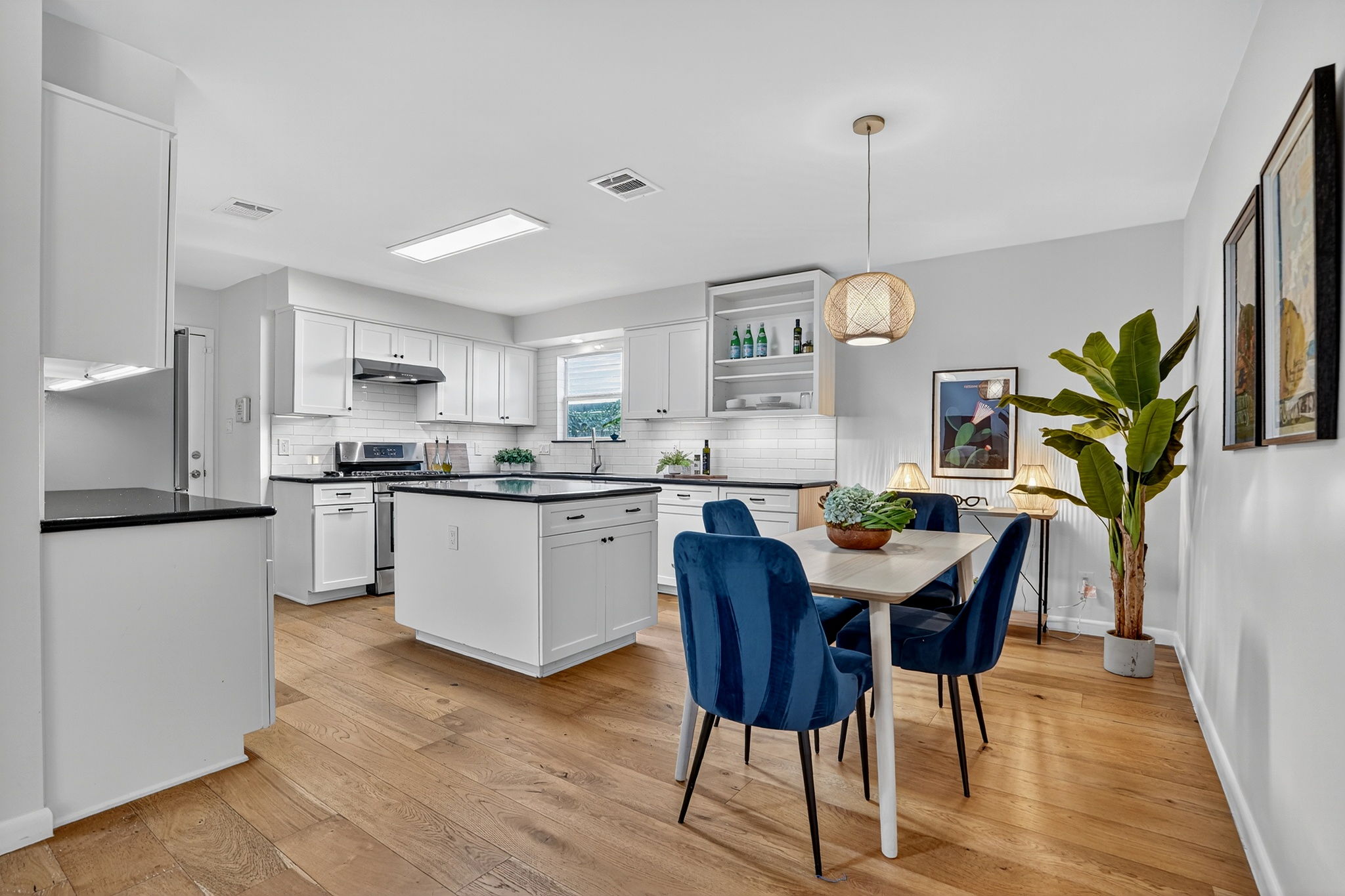 3202 Western Drive Austin, TX 78745 - Photo 7 of 34 a kitchen with stainless steel appliances granite countertop white cabinets a refrigerator a stove a dining table and chairs with wooden floor