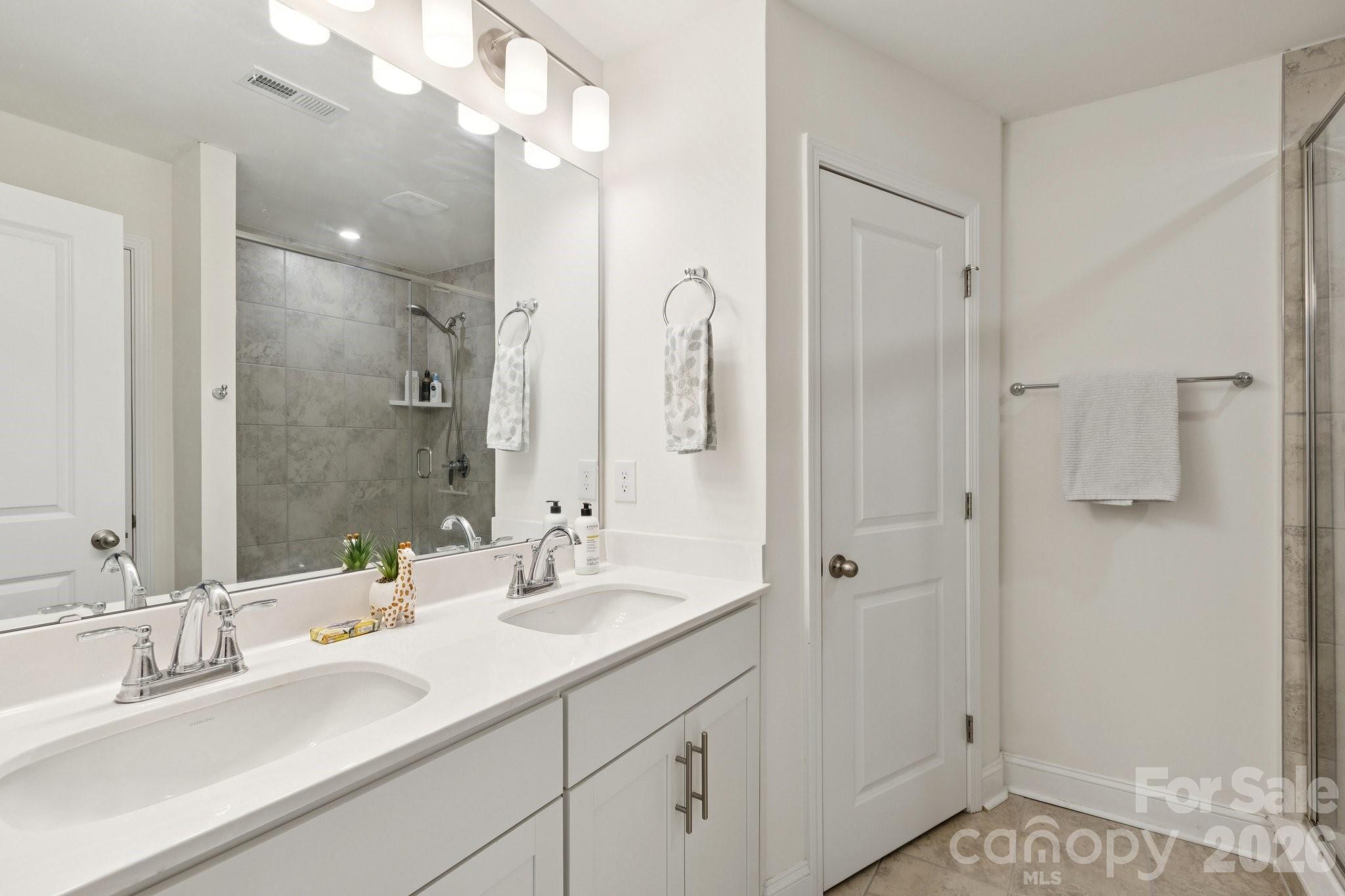 2081 Suttonview Road Fort Mill, SC 29708 - Photo 17 of 33 a bathroom with a double vanity sink mirror and shower