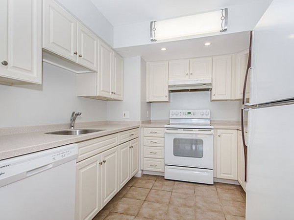 1731 Beacon Street, Unit 1110 Brookline, MA 02445 - Photo 2 of 24 a kitchen with white cabinets and white appliances