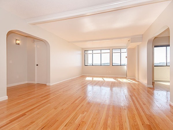 1731 Beacon Street, Unit 1110 Brookline, MA 02445 - Photo 5 of 24 an empty room with wooden floor and windows