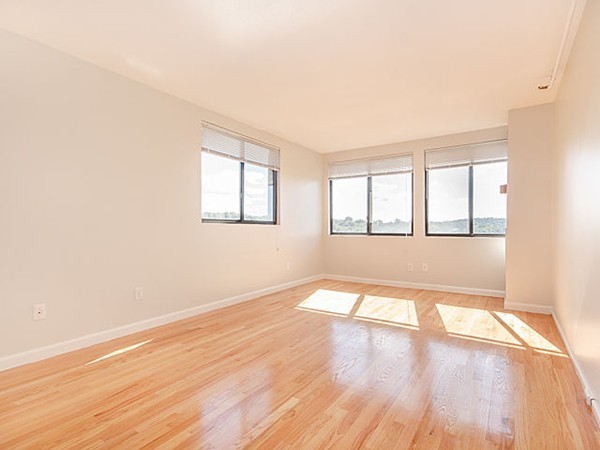 1731 Beacon Street, Unit 1110 Brookline, MA 02445 - Photo 7 of 24 an empty room with wooden floor and windows