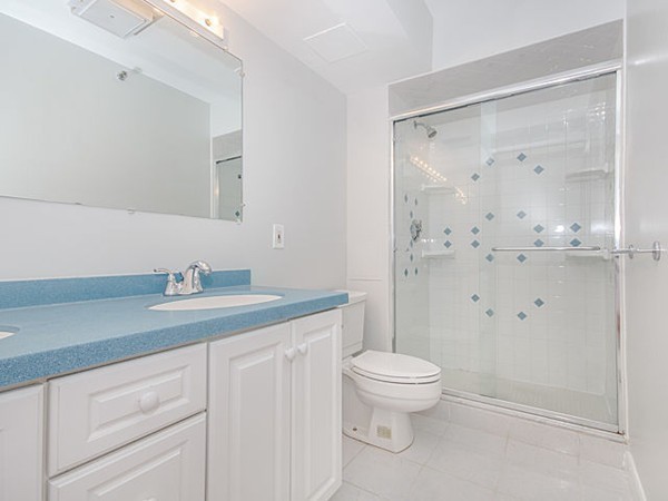 1731 Beacon Street, Unit 1110 Brookline, MA 02445 - Photo 9 of 24 a bathroom with a granite countertop sink a toilet and a shower