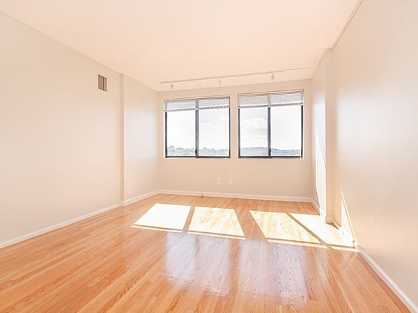 1731 Beacon Street, Unit 1110 Brookline, MA 02445 - Photo 10 of 24 an empty room with wooden floor and windows