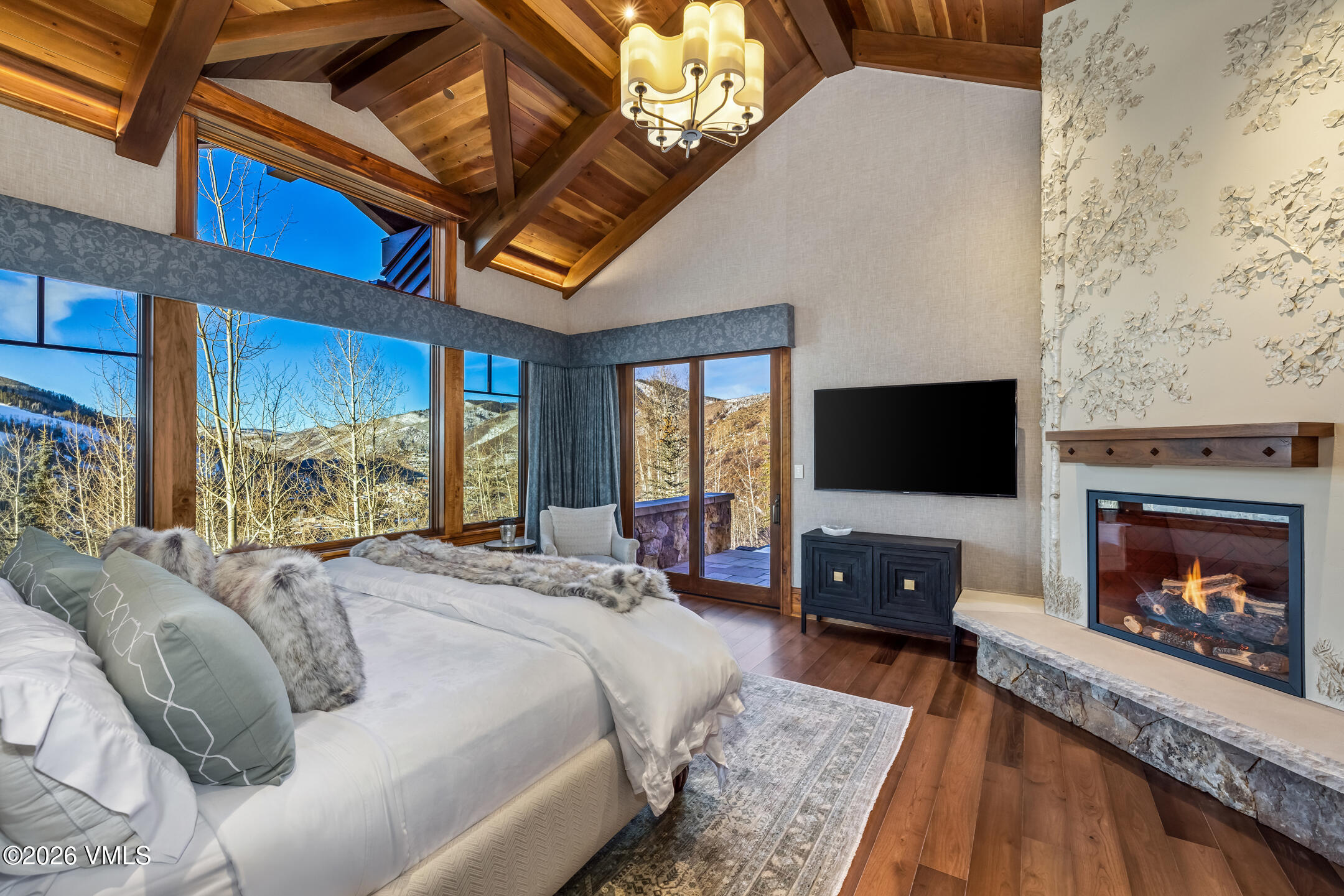 1000 Spraddle Creek Road Vail, CO 81657 - Photo 11 of 26 a bedroom with a bed a fireplace and a flat tv screen