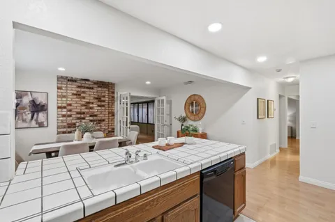 a living room with large couches and kitchen view with wooden floor
