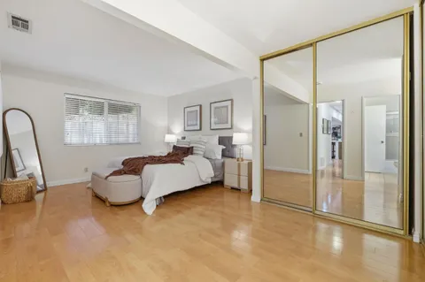 a spacious bedroom with a bed couch and a window