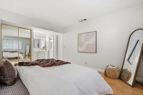 a bedroom with a bed and wooden floor