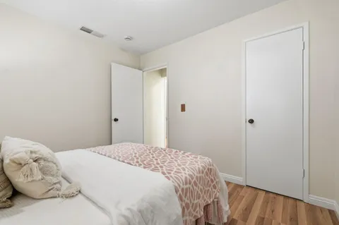 a bedroom with a bed and wooden floor