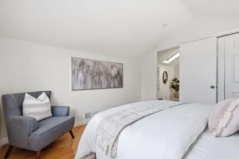 a bedroom with a bed couch and a window