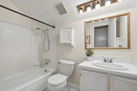 a bathroom with a sink toilet vanity and shower
