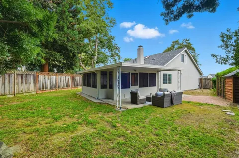 a view of a house with a yard and sitting area