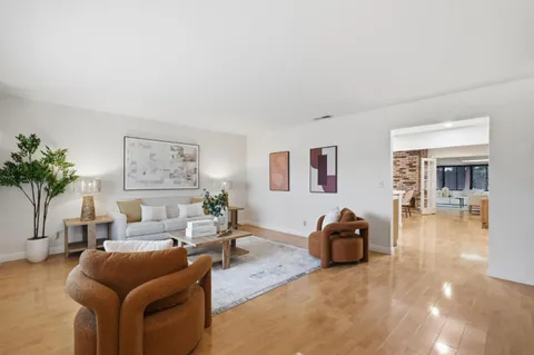 a living room with furniture a window and a wooden floor