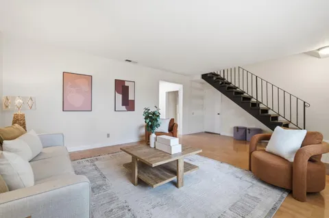 a living room with furniture and a wooden floor