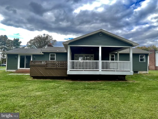 a view of a house with a yard and deck