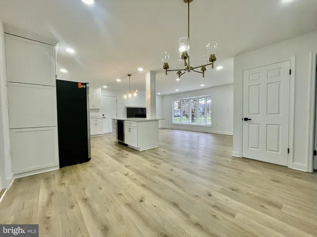 a view of a kitchen with stainless steel appliances granite countertop a refrigerator a stove and a wooden floors