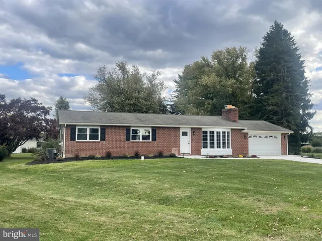 a view of a house with a yard and trees