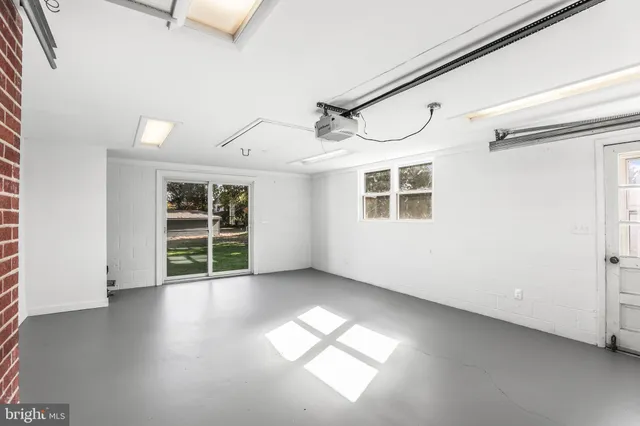 an empty room with wooden floor ceiling fan and window