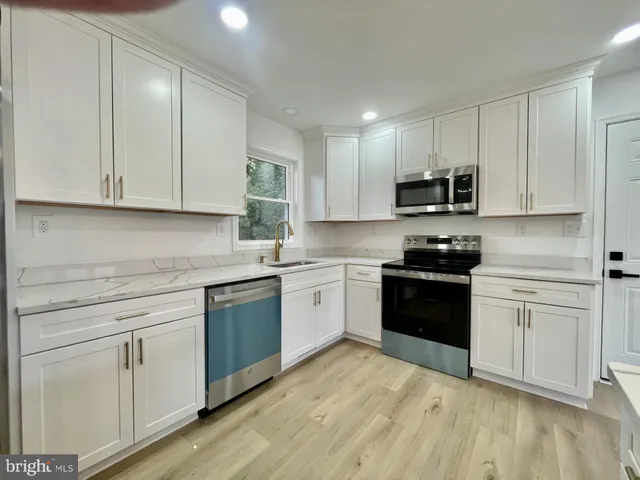 a kitchen with granite countertop white cabinets and appliances