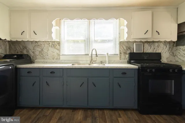 a kitchen with stainless steel appliances granite countertop a sink a stove and a microwave