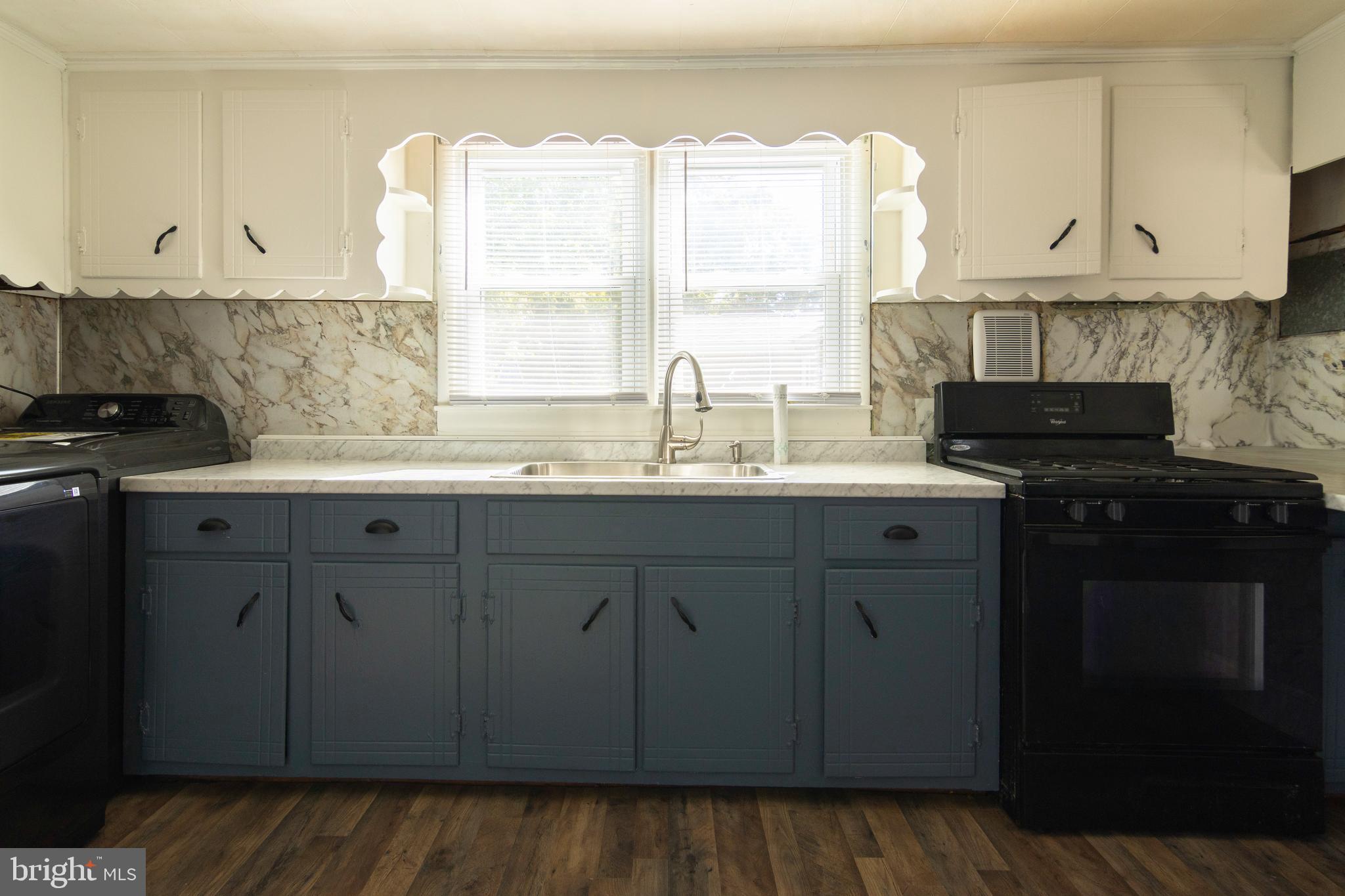 809 Truman Street Cambridge, MD 21613 - Photo 17 of 25 a kitchen with stainless steel appliances granite countertop a sink a stove and a microwave