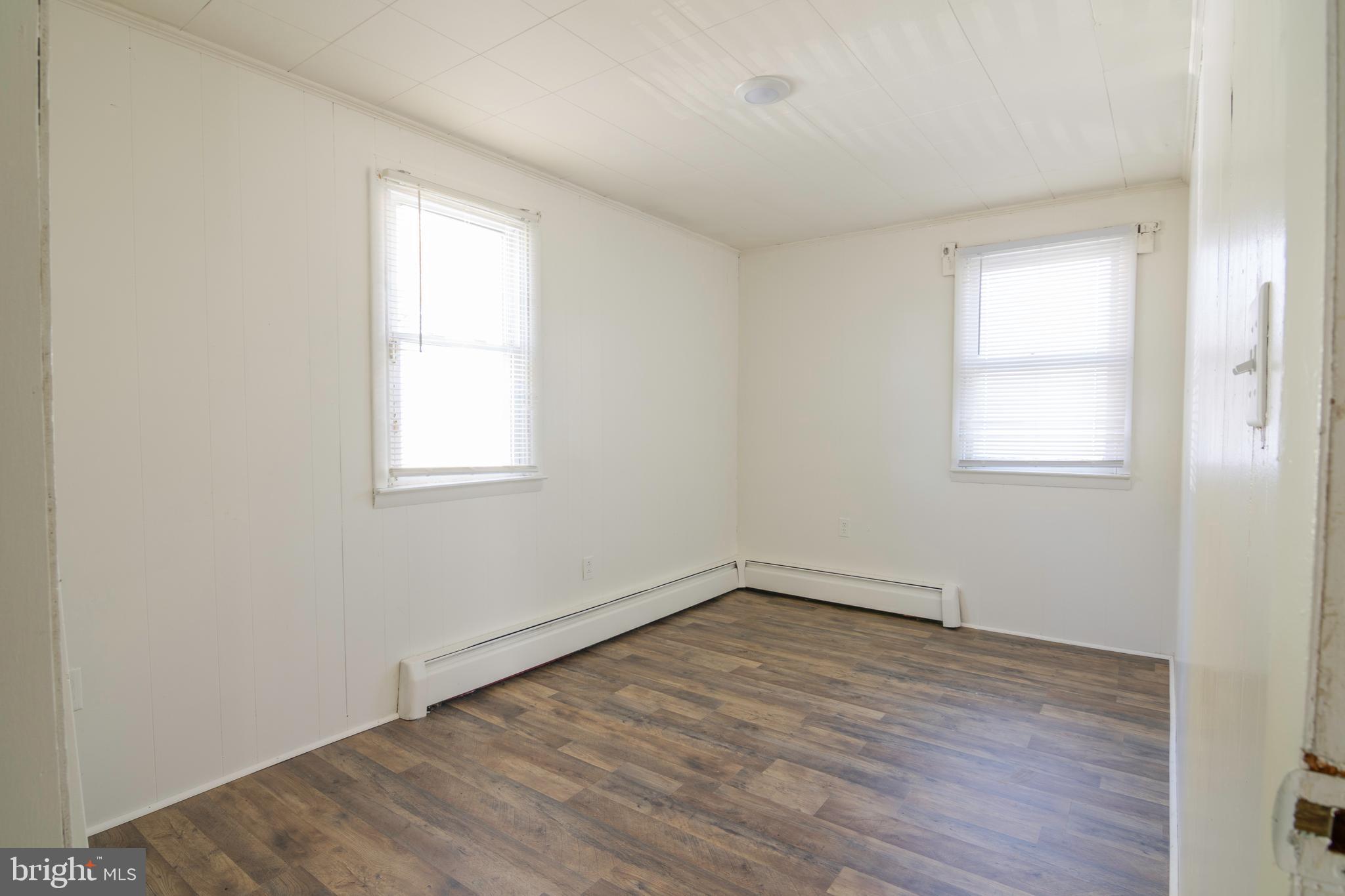809 Truman Street Cambridge, MD 21613 - Photo 19 of 25 an empty room with wooden floor and windows