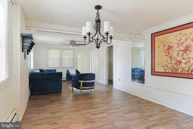 a view of a livingroom with furniture wooden floor windows and a chandelier