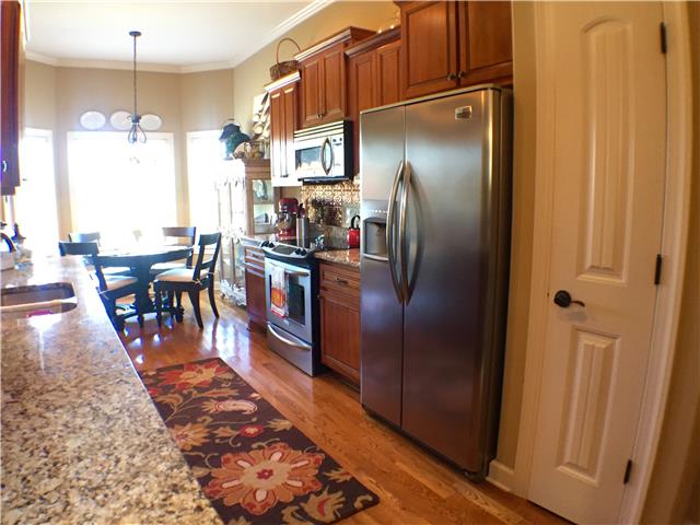 525 Sugar Flat Road Lebanon, TN 37087 - Photo 6 of 20 a kitchen with stainless steel appliances granite countertop a refrigerator a stove and a dining table with wooden floor
