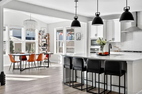 a kitchen with a dining table chairs and white cabinets