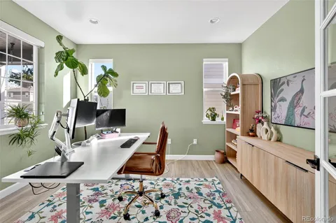 a dining room with wooden floor a chandelier a glass table and chairs