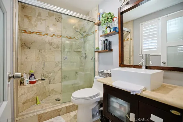 a bathroom with a sink a toilet and shower