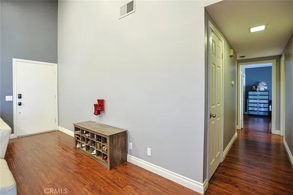 a hallway with wooden floor and cabinet