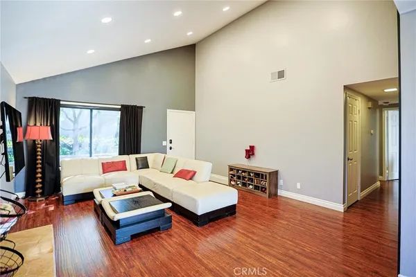 a living room with furniture and a wooden floor