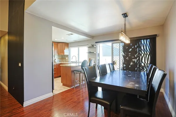 a view of a dining room and livingroom with furniture wooden floor a chandelier